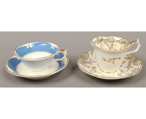 Two Rockingham tea cup and saucer duos one with grey enamel and gilt decoration, the other blue ground with gilt decoration b