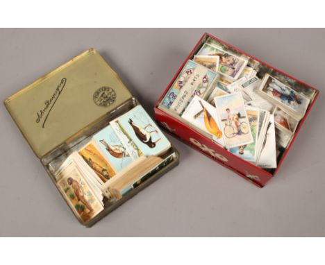 Two tins of tea and cigarette cards.
