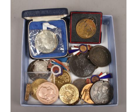A collection of medals and enamel badges to include commemorative and coronation examples.