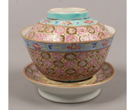 A Chinese famille rose rice bowl and cover on stand printed seal marks.Condition report intended as a guide only.Minor chip o