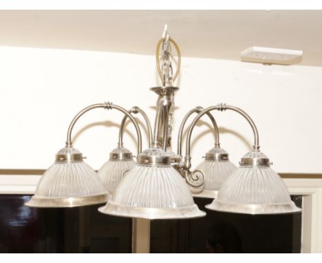 A brush brass five branch ceiling light with clear ribbed glass shades.
