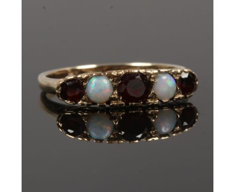 A 9ct gold five stone ring set with opals and garnets, size N1/2.