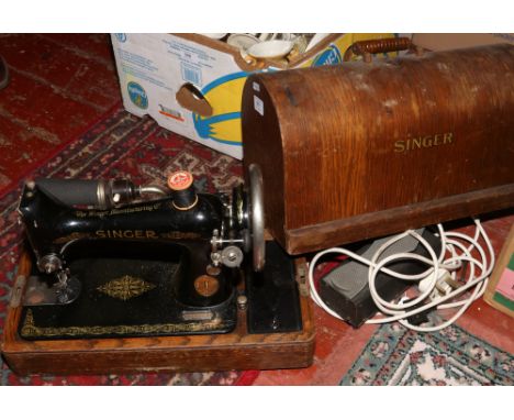 An oak cased Singer sewing machine with adjustable light, no key.