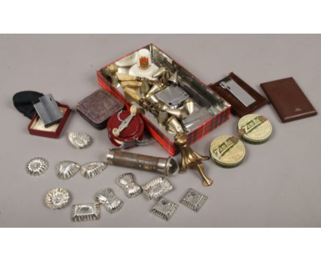 A tin of vintage collectables including cigarette and pipe lighters, chocolate moulds, 1950s toy fishing reel, Ever-Ready bul