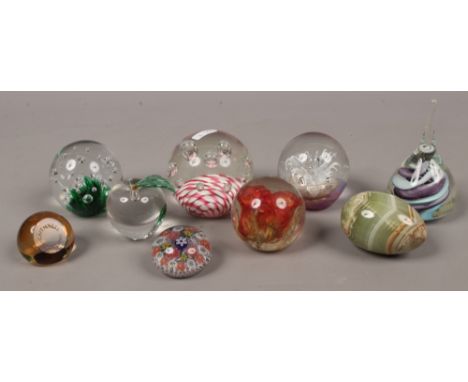 A collection of glass paperweights including Caithness and an onyx egg.