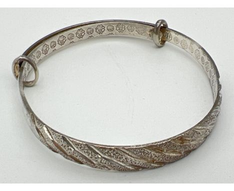 A 925 silver expanding bracelet with diamond cut brushed and plain silver design. Chinese character detail to inside with sil