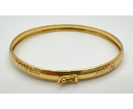 A silver gilt bangle with diamond cut criss cross pattern throughout. Push clasp and safety clip. Marked 925 inside band. App