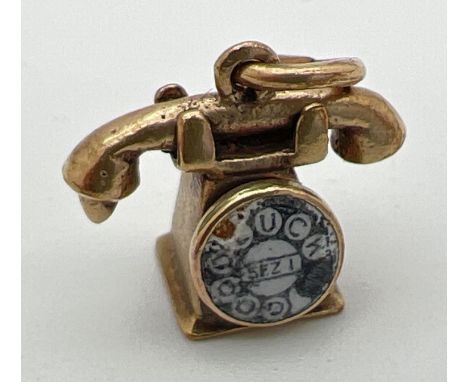 A 9ct gold pendant/charm modelled as a telephone with enamel detail to dial. Gold marks to base and back. Approx. 1.75cm x 1.