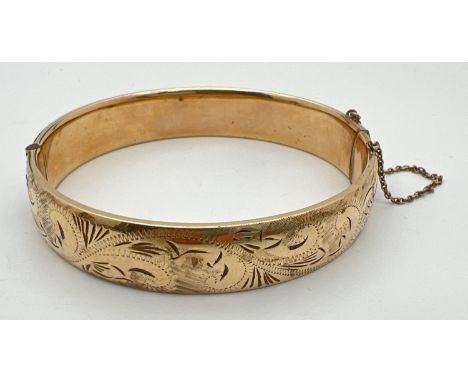 A vintage 9ct rolled gold bangle with half floral engraved pattern, push clasp and safety chain. Gold marks to clasp. Approx.