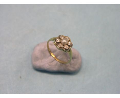 A yellow metal rosette ring, set six small diamonds and central pearl, unmarked, size K