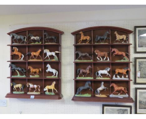 A full set of twenty-four Franklin Mint ceramic horse models, each named, displayed within purpose-made mahogany shelf units