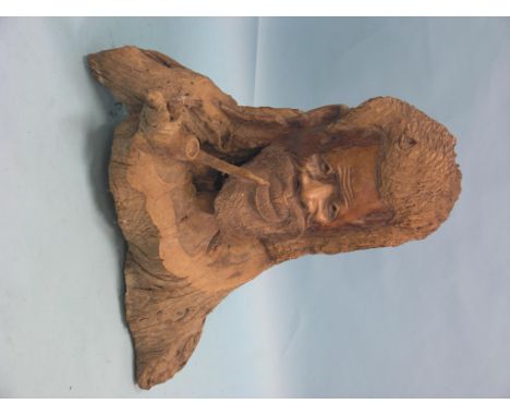 A large West Indian carved tree-trunk, portrait bust of a bearded male native smoking pipe, 31in. high