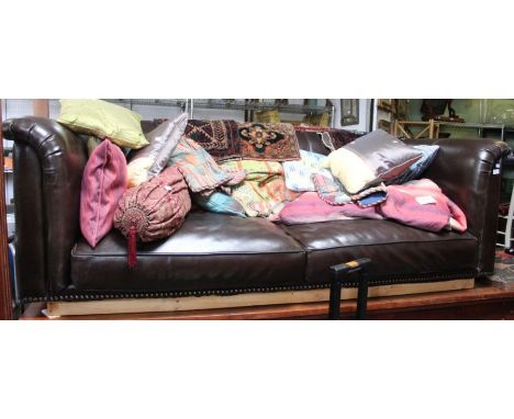 A large dark brown leather sofa on stand