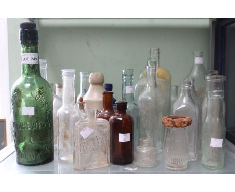 A shelf full of old bottles includes a Flower and Sons green bottle S-on-A