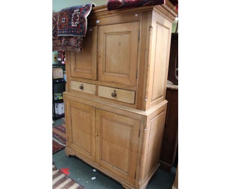 A 19th century stripped pine two piece House Keepers cupboard, having two upper doors over two drawers, the base section havi