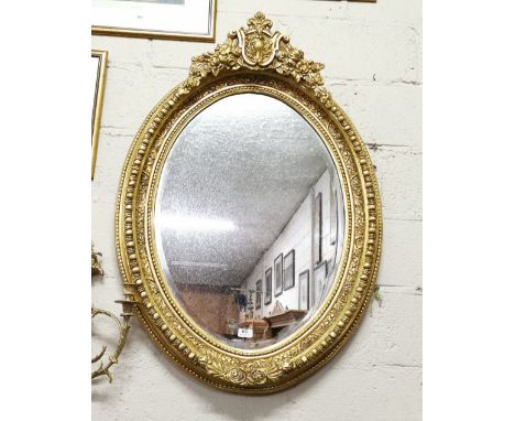 Ornate Oval-Shaped Gilt Framed Wall Mirror with decorative borders and finial, 116cm h x 78 cm h 
