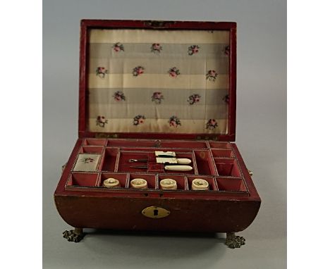 A leather and brass bound sewing casket, late 18th/early 19th century, of squat sarcophagus form, with lions mask and ring ha