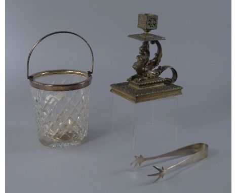 An Edwardian pierced brass candlestick, the stem in the form of a chimera with scrolling form tail handle, on rectangular bas