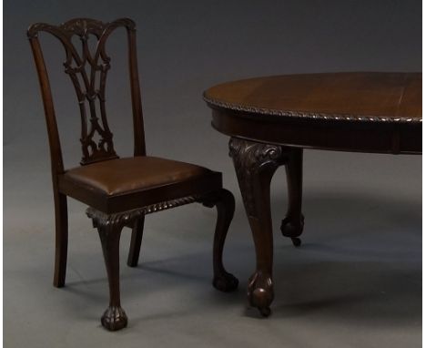 A mahogany oval dining table, 20th century, with two leaves, the top with carved edge, on cabriole legs with claw and ball fe