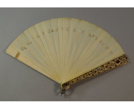 An ivory fan, late 19th century, the guard sticks with enamel gilt metal filigree mounts, set with pearl, turquoise and garne