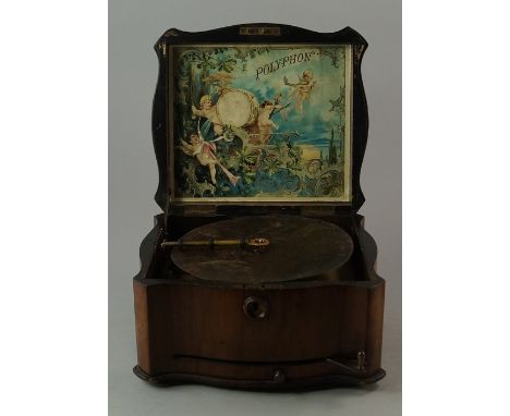 A Polyphon walnut cased music box, late 19th century, the shaped case with lifting lid fitted to the interior with a lithogra