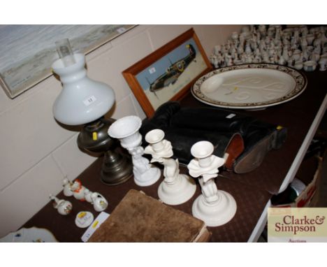 A brass oil lamp with opaque glass shade a pair of Leeds pottery candlesticks and a white glazed cherub decorated vase