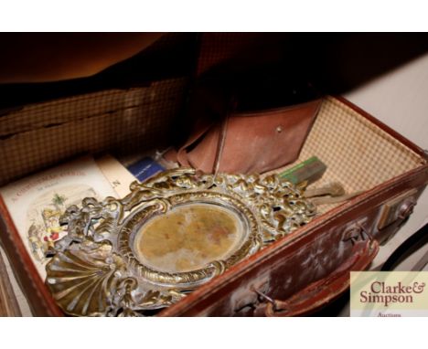 A leather travelling case and miscellaneous contents to include a brass cherub decorated mirror, box Brownie camera, books et