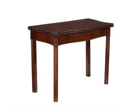 A George III mahogany card table, circa 1770, of serpentine outline with canted angles, the top opening to a baize playing su