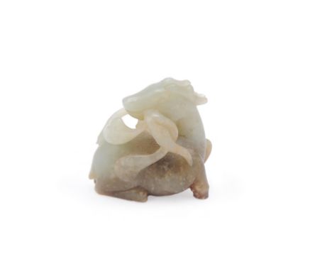 A Chinese celadon and russet jade carving of a deer, late Qing Dynasty, recumbent with head turned back holding a Lingzhi fun
