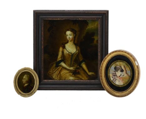A George III silkwork picture of a lady reading, late 18th century, within verre eglomise border and gilt composition oval fr