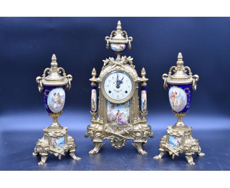 A French style brass cased clock garniture with urn finial and blue glaze with decorative panels resting on swept paw support