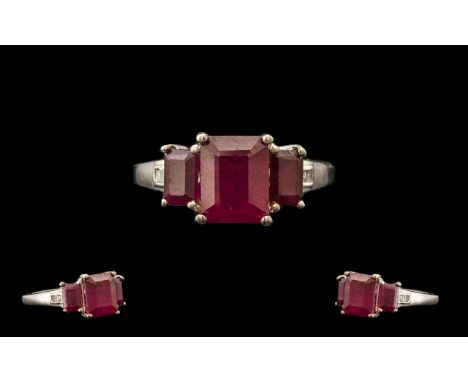 Ruby and Diamond Ring, an octagon cut 3.5ct ruby of rich red colour, flanked by two similar rubies of .5ct each, accented by 