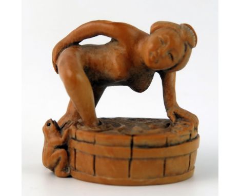 A Japanese carved Boxwood erotic netsuke of a female taking a bath, 4cm wide.