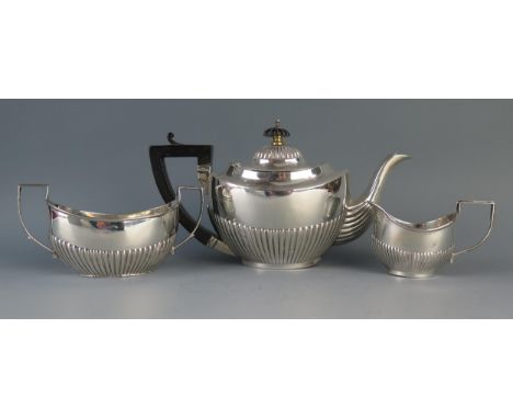 A matched silver three-piece bachelors tea service, of oval outline with half reeded decoration, includes teapot, sugar basin