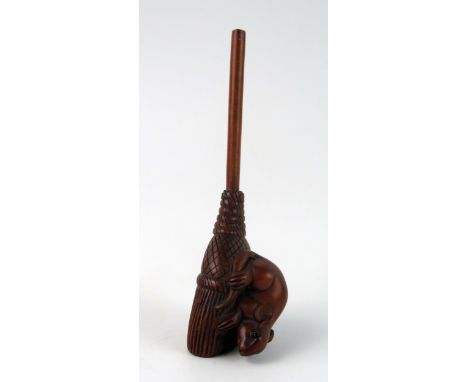 A Japanese carved boxwood netsuke of a rat on a broom, unsigned, 9cm long. 