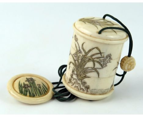 A Japanese carved bone three-section inro of cylindrical outline, decorated with butterflies amongst flowering shrubs, 4.5cm 
