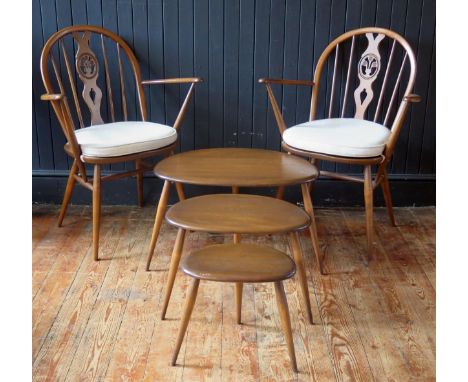 A pair of Ercol Fleur d'Lys Windsor chairs with arched back, swept arm supports and solid seat on turned underframimg. togeth