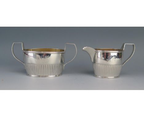 A Sterling silver cream jug and matching twin handled sugar basin, stamped sterling, monogrammed, of oval outline with half r
