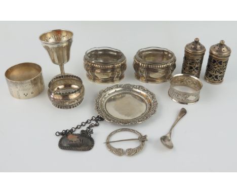 A mixed collection of silverwares, various makers and dates, includes, napkin rings, egg cup, salt, brooch, pepperette, and d