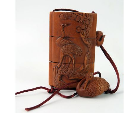 A Japanese carved boxwood, three section inro, carved in low relief storks, 9.5cmm long with boxwood ojime of a bird feeding 