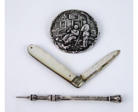 A continental silver circular brooch decorated with figures in low relief 5.5cm diameter, a silver pencil and a silver bladed