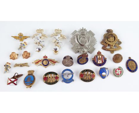 A collection of assorted army cap badges, sweetheart brooches, and other lapel badges. 