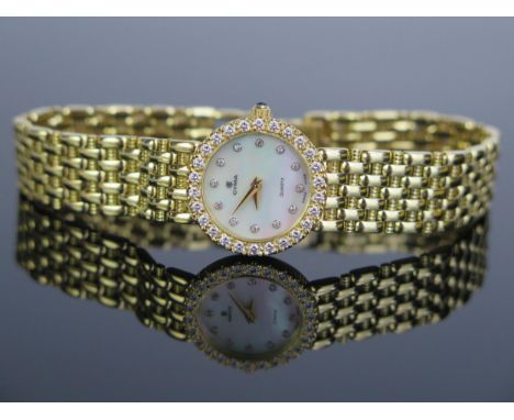 A CYMA Ladies 18ct Gold Wristwatch with diamond set bezel and mother of 20mm pearl dial with further inset diamonds to the ho