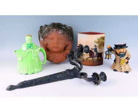 A terracotta wall pocket in the form of a cherubs face, a 'Little Old Lady' teapot, a pottery figure of a nightwatchman,  a B