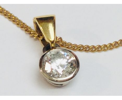 A solitaire diamond pendant, round brilliant cut, set in an 18ct white gold rub-over setting with yellow gold bale, estimated