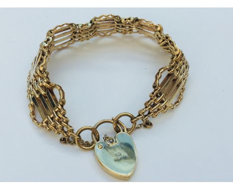 A 9ct yellow gold gate bracelet with engraved heart padlock, weighing 24.2 grams. 