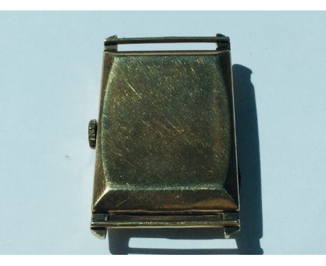 A 9ct gold Rectangular watch face, J.W. Benson London, weighing 14.3 grams. Together with a 9ct gold Zebra novelty charm, wei
