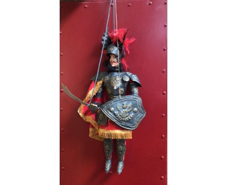 An Italian carved wooden and metal rod puppet of a knight 'Orlando', with red feathered plumed helmet, embossed metal armour,