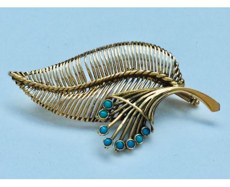 A 9ct gold brooch modelled as a fern leaf, set with eight small cabochon cut turquoise, weighing 9.2 grams. 