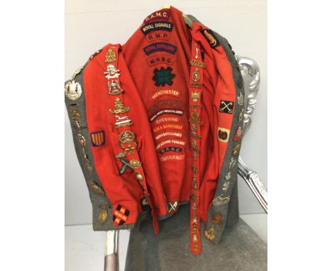 A WWII grey and red woollen Queen Alexandra's Royal Nursing Corp nurse's cape adorned with 50+ military cap badges and cloth 